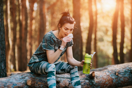 Woman eating a snack in a forest