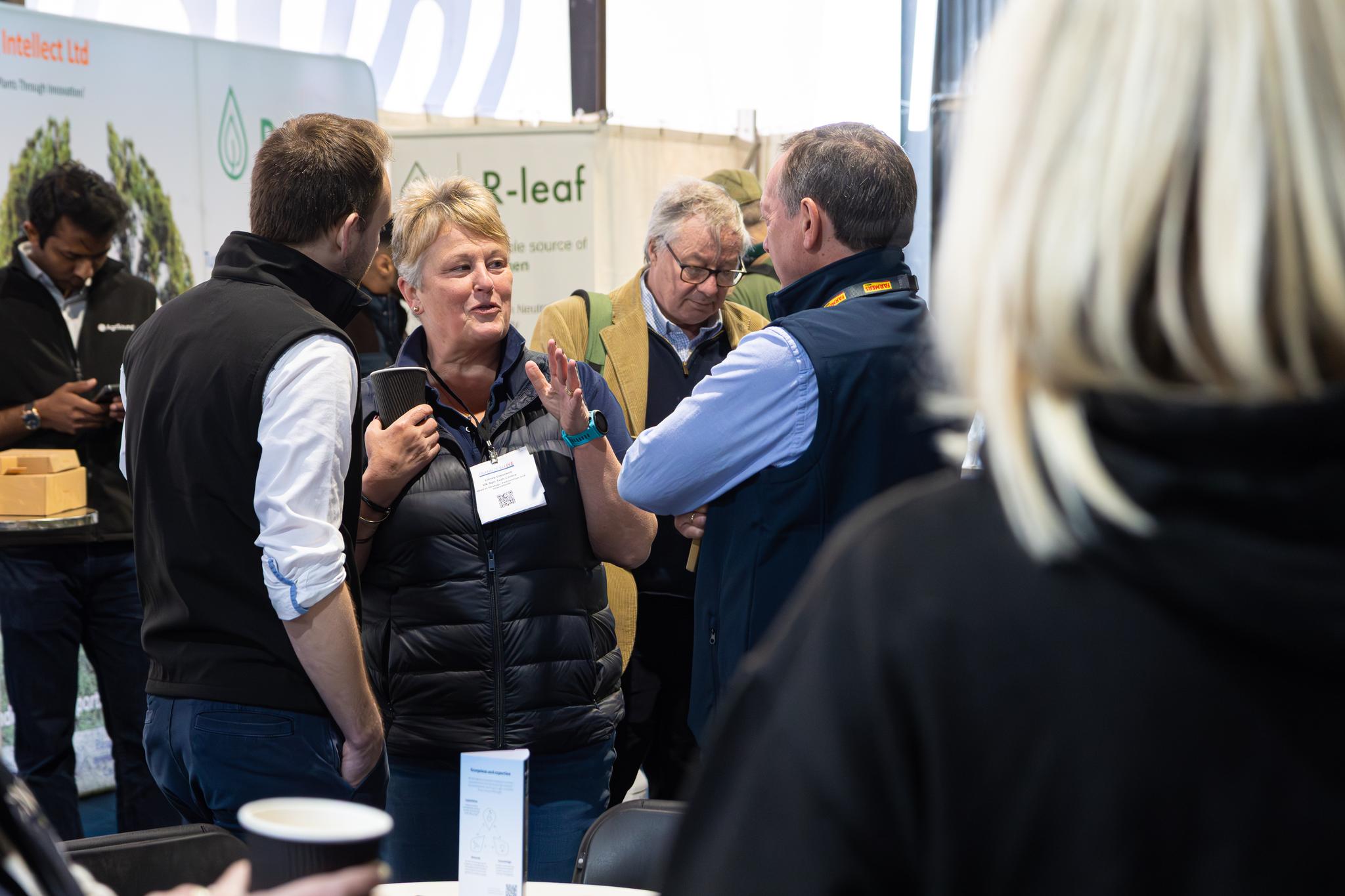 Exhibitors chatting with visitors at an agricultural event