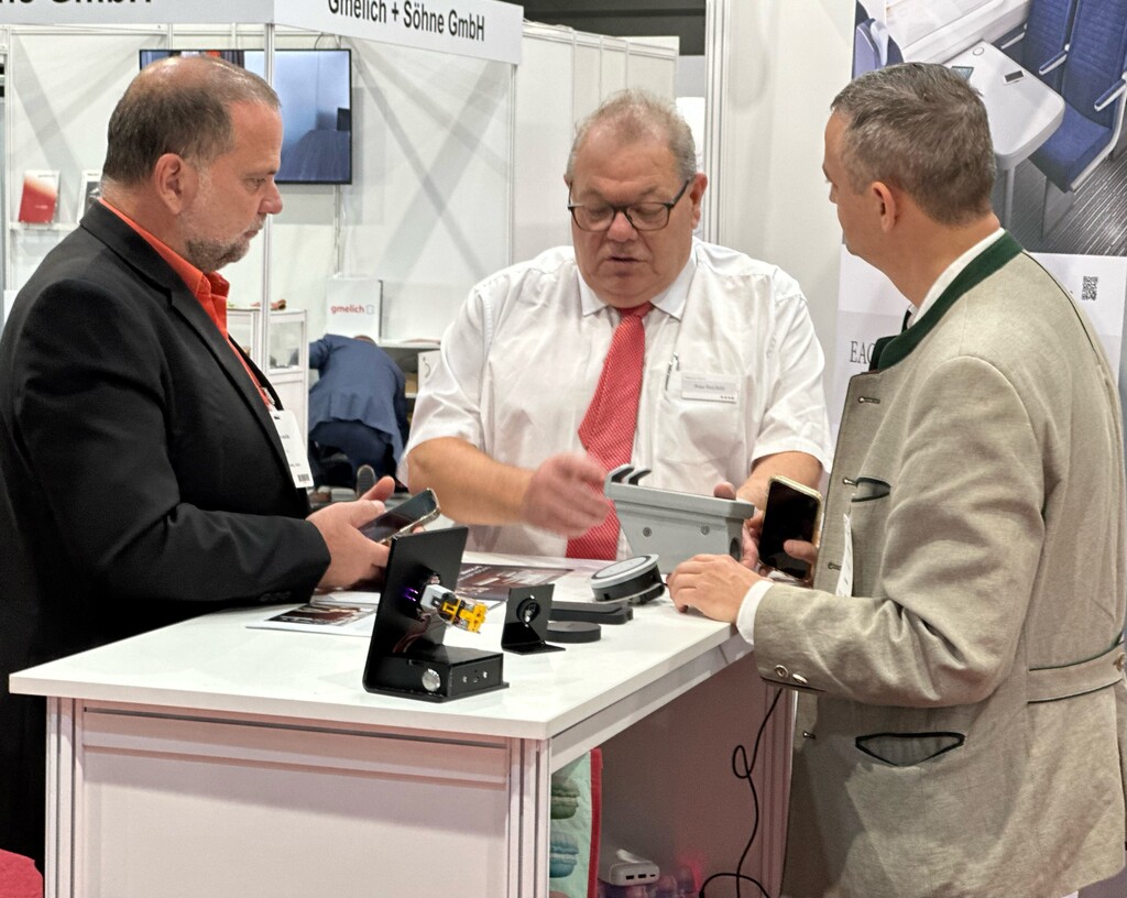 Visitors discussing rail interior components at an exhibition stand
